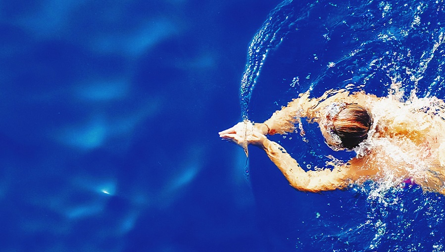 nő kék vízben úszik