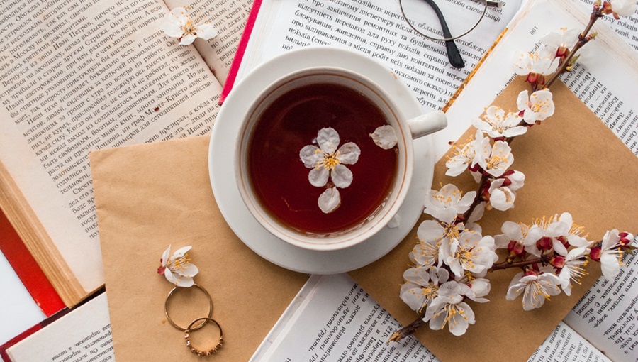 csésze tea könyvek gyűrűk virág szemüveg