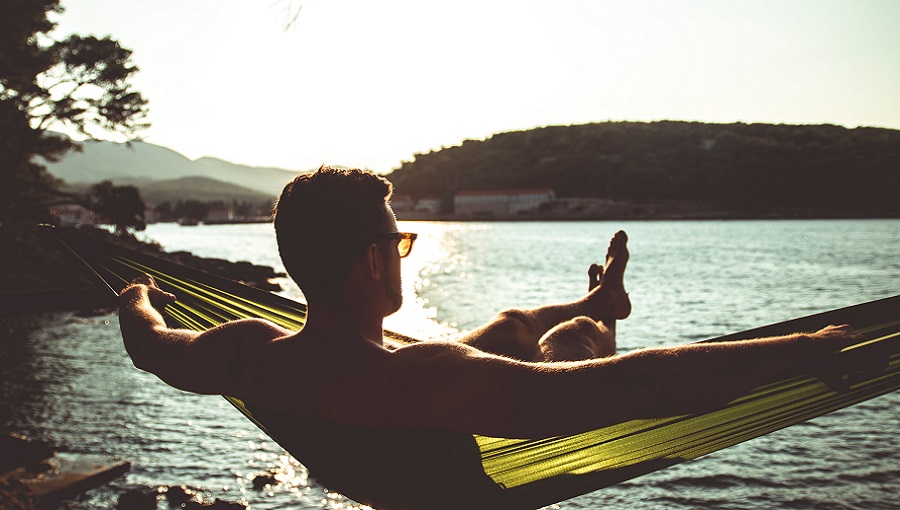 nyugágyban ejtőző strandoló férfi